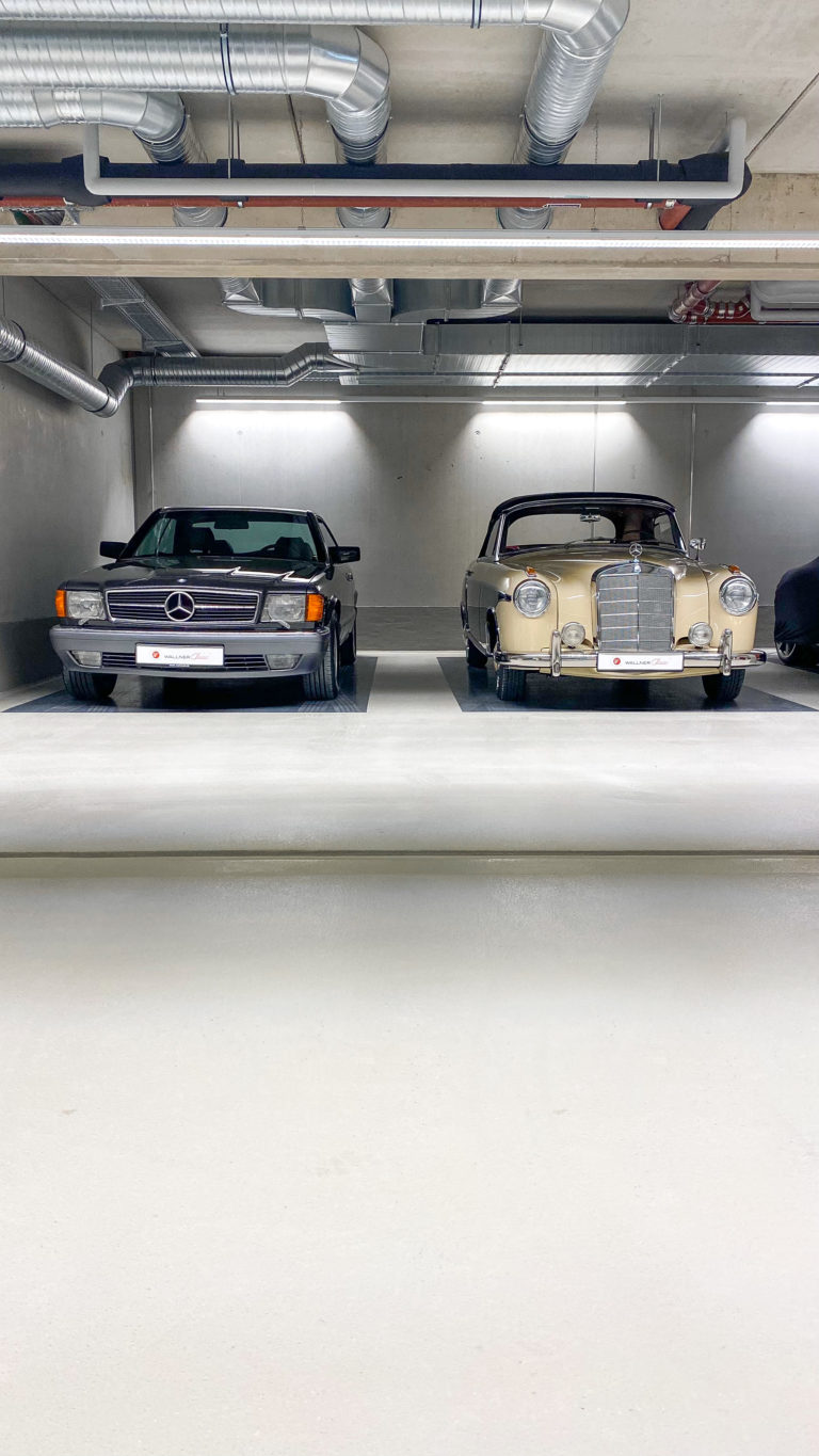 Zwei Mercedes Oldtimer schwarz und cremé in einer Garage