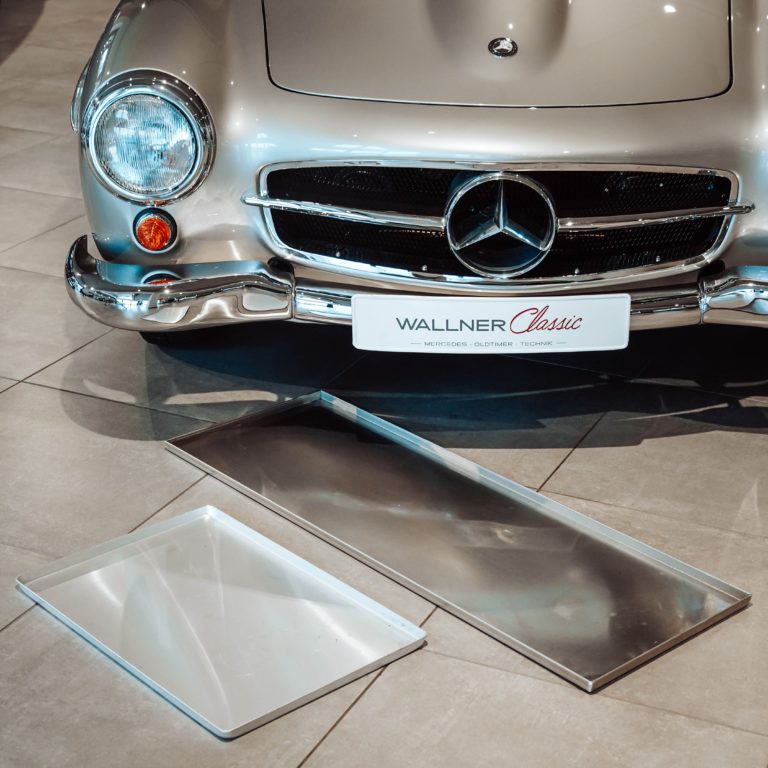 Zwei Ölwannen vor einem Mercedes 190 SL