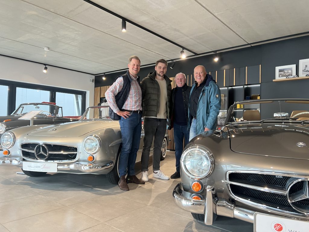 4 Personen in einem Verkaufsraum für Oldtimer