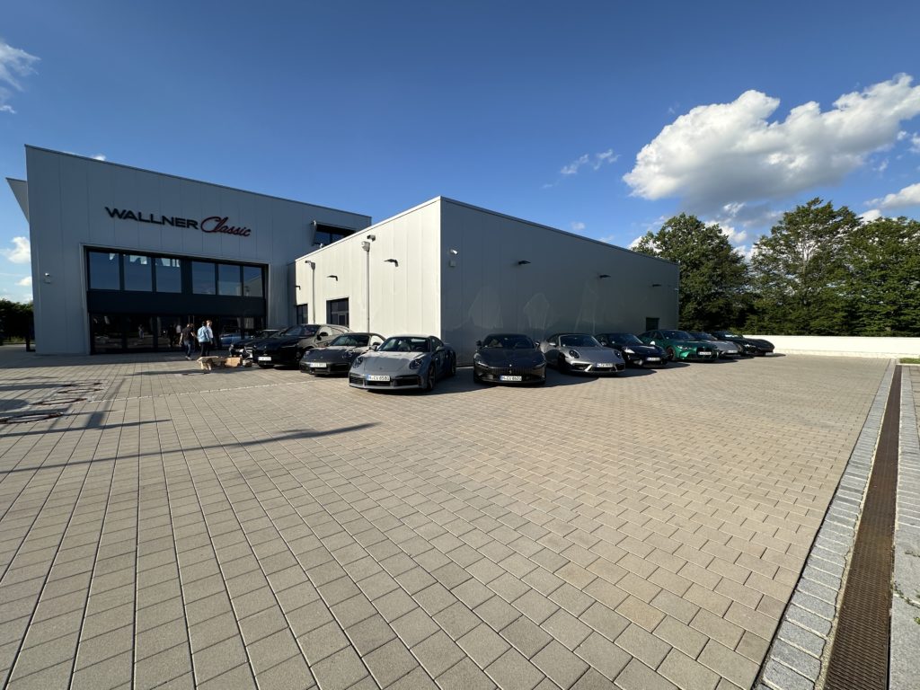 Zu sehen ist das Gebäude von Wallner Classic. Vor dem Gebäude sind mehrere Fahrzeuge geparkt.