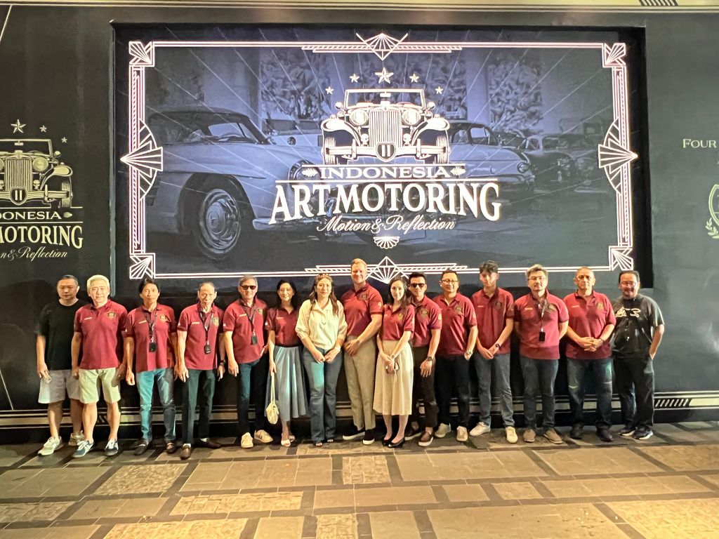 Die Teilnehmer am Indonesia Art Motoring vor dem Plakat