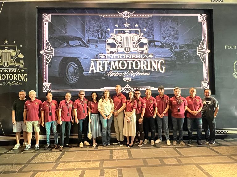 Die Teilnehmer am Indonesia Art Motoring vor dem Plakat